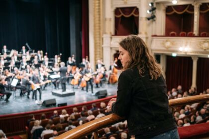 Jeune femme regardant le concert depuis le balcon